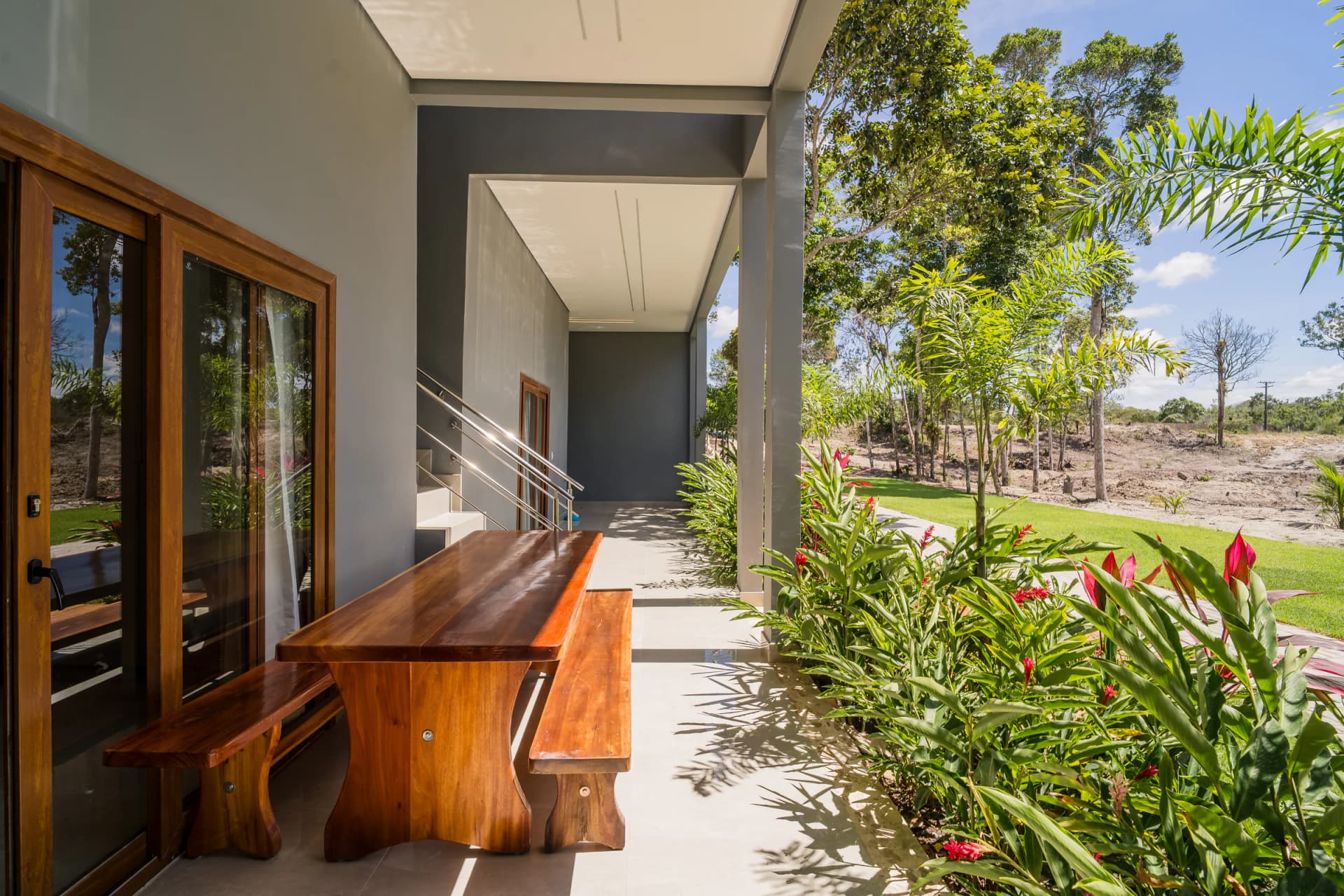 Mesa da varanda e jardim ao redor no Residencial Marinho, Arraial d’Ajuda.